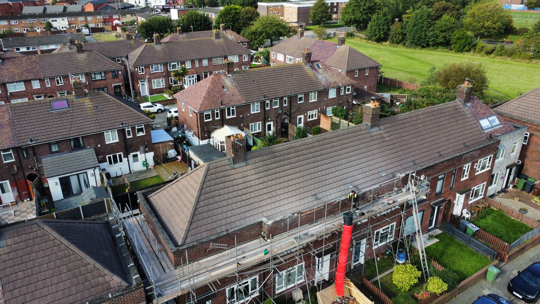 Large scaffolded roofing project on terraced properties